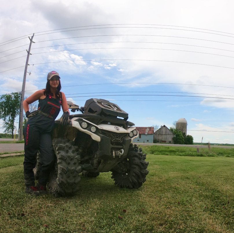 Beautiful girl in the field next to the ATV